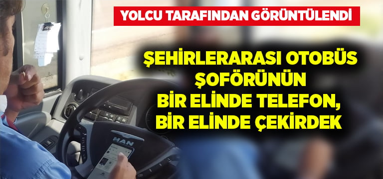 Şehirlerarası otobüs şoförünün bir elinde telefon, bir elinde çekirdek